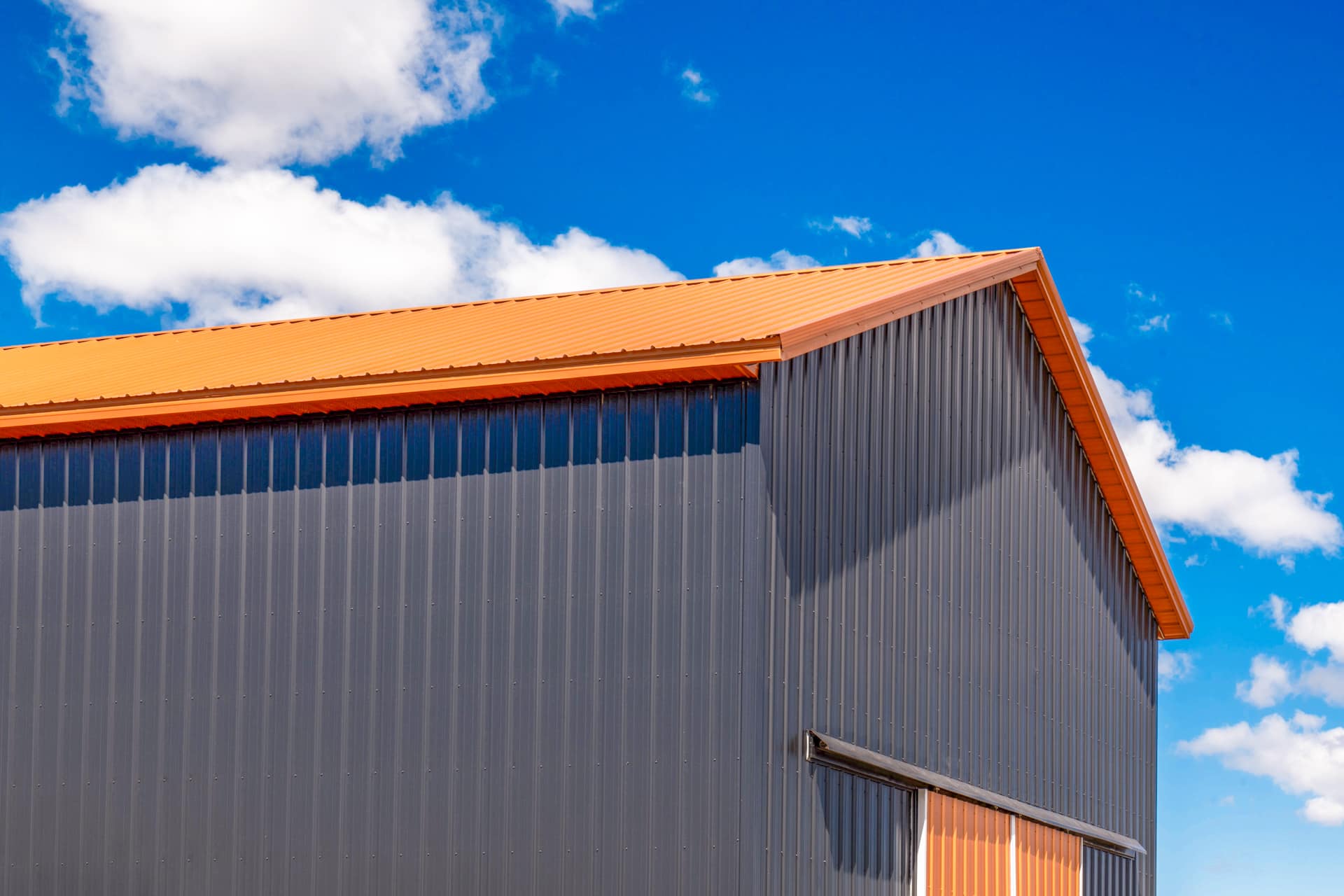 Gray metal siding and orange metal roofing on a garage in Raton NM