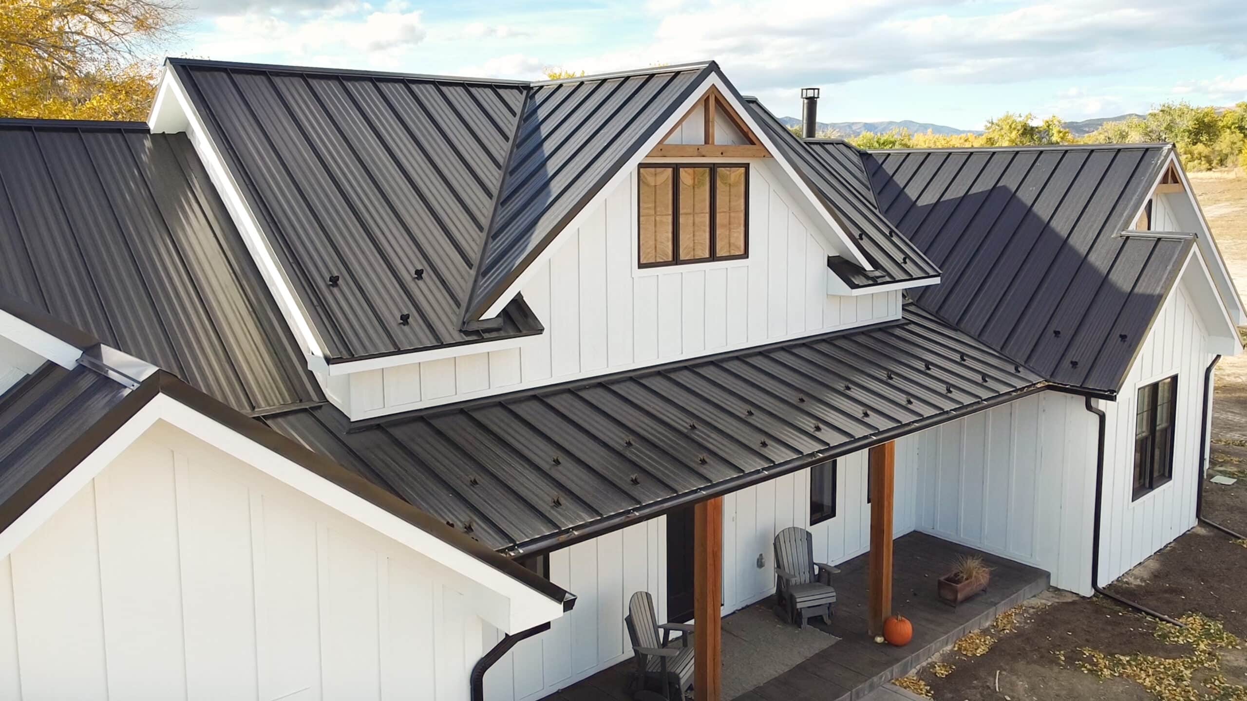 Large house with black metal roof and white metal siding in Lakewood CO scaled